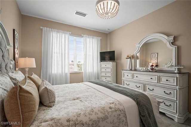 tiled bedroom with a chandelier and visible vents