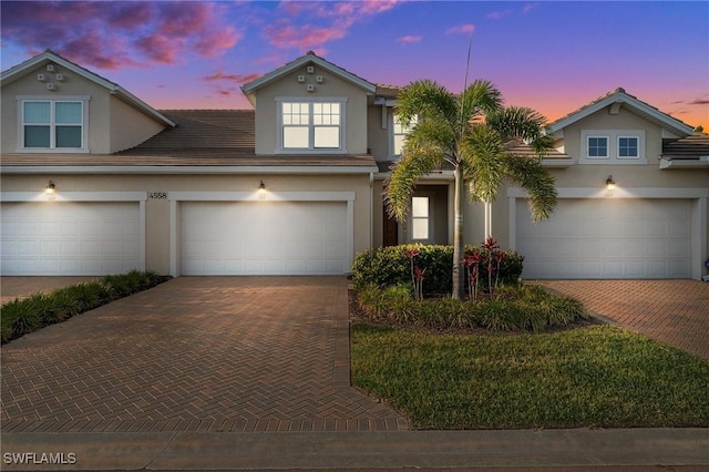 4558 Arboretum Cir Unit 103, Naples, FL 34112 - view of front of property with decorative driveway, stucco siding, and an attached garage