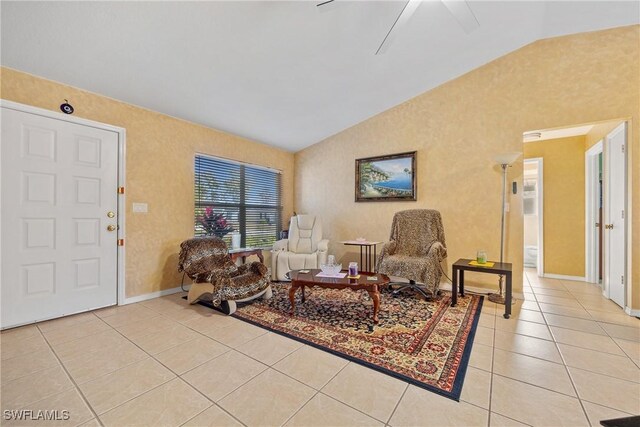 living area with lofted ceiling, light tile patterned floors, and ceiling fan