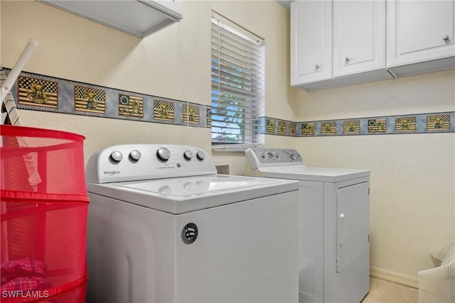 laundry area with separate washer and dryer and cabinet space