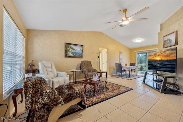 living area featuring lofted ceiling, light tile patterned flooring, and ceiling fan