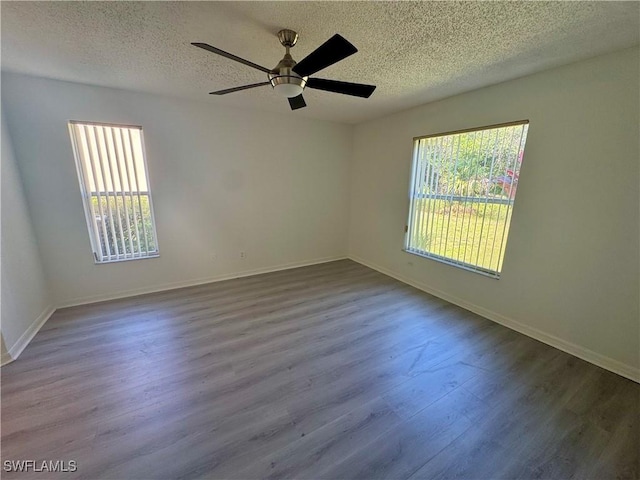 empty room with a textured ceiling, ceiling fan, wood finished floors, and baseboards