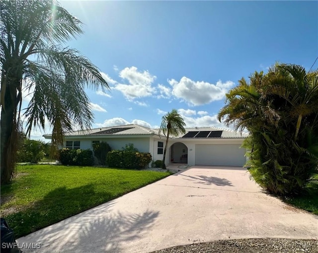 4343 S Gulf Cir, North Fort Myers, FL 33903 - ranch-style house featuring an attached garage, roof mounted solar panels, a front lawn, driveway, and stucco siding