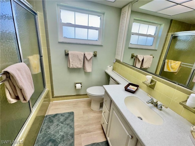 4343 S Gulf Cir, North Fort Myers, FL 33903 - bathroom with vanity, toilet, baseboards, wood finished floors, and tasteful backsplash