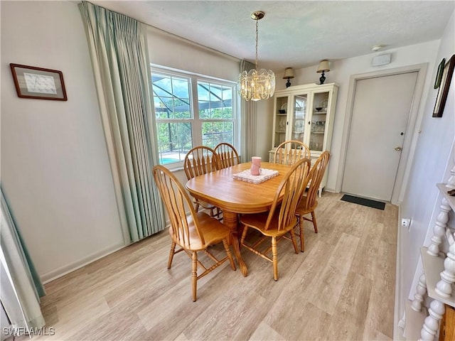 4343 S Gulf Cir, North Fort Myers, FL 33903 - dining room with light wood-type flooring, a chandelier, and a textured ceiling