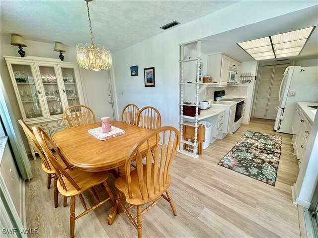 4343 S Gulf Cir, North Fort Myers, FL 33903 - dining room with a chandelier and light wood-style flooring