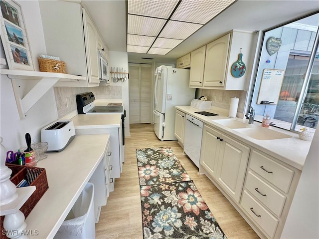 4343 S Gulf Cir, North Fort Myers, FL 33903 - kitchen with white appliances, a sink, light wood-type flooring, and light countertops