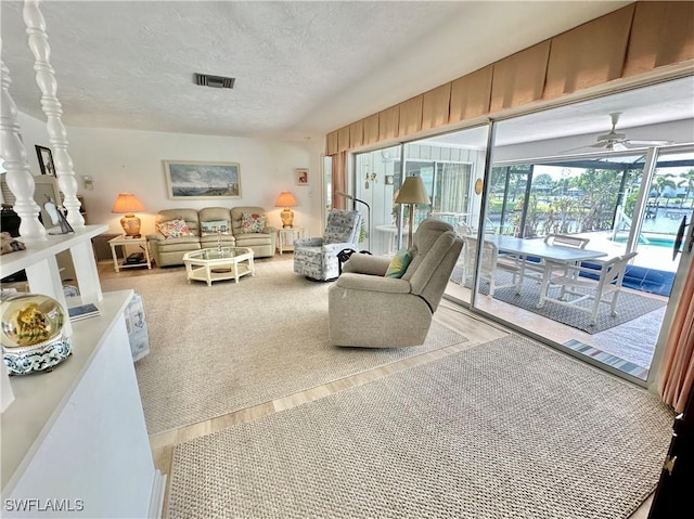 4343 S Gulf Cir, North Fort Myers, FL 33903 - living area featuring a textured ceiling, a ceiling fan, and carpet floors