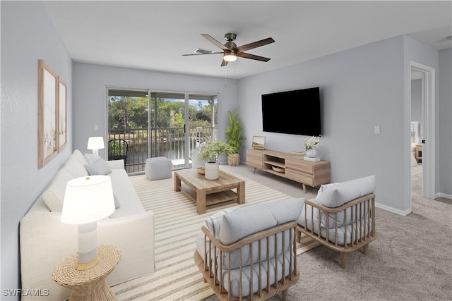 carpeted living room featuring a ceiling fan and baseboards