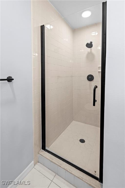 bathroom featuring a stall shower and baseboards