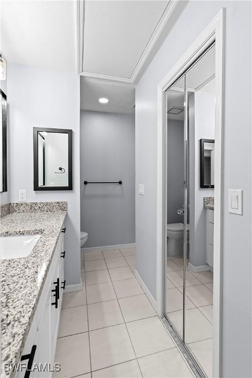 full bathroom with tile patterned floors, baseboards, toilet, and vanity
