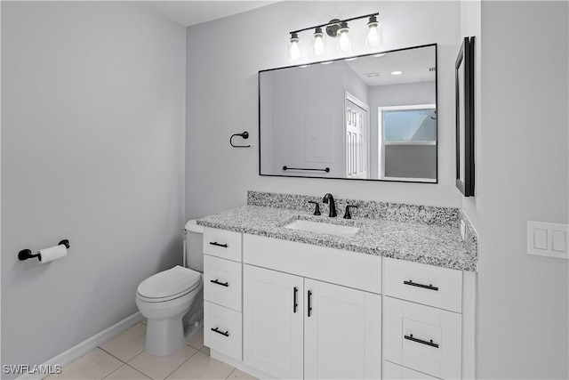 bathroom featuring baseboards, tile patterned floors, toilet, and vanity