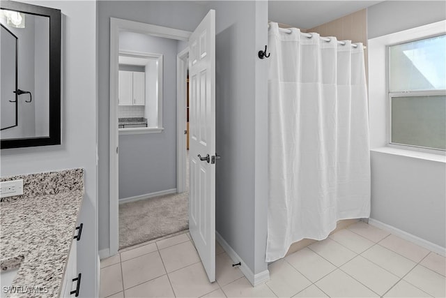 full bath featuring curtained shower, tile patterned flooring, and baseboards