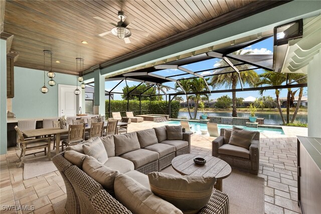 view of patio / terrace with glass enclosure, a water view, a ceiling fan, an outdoor hangout area, and a pool with connected hot tub