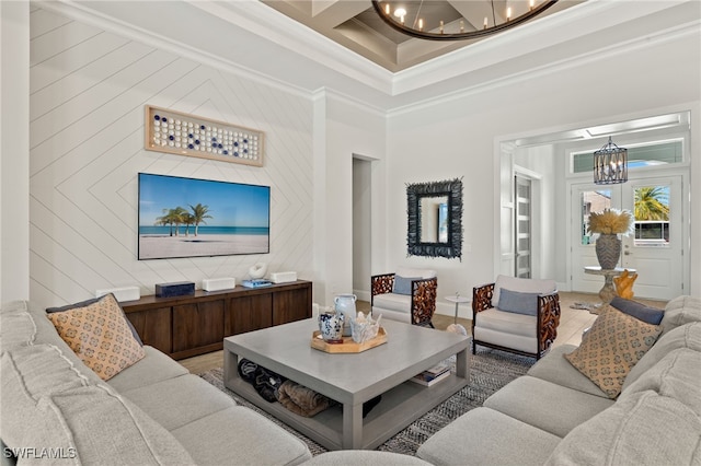 living room featuring crown molding, a high ceiling, baseboards, coffered ceiling, and a notable chandelier