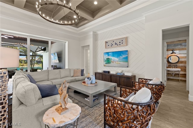 living room with wood finished floors, a chandelier, beamed ceiling, coffered ceiling, and ornamental molding