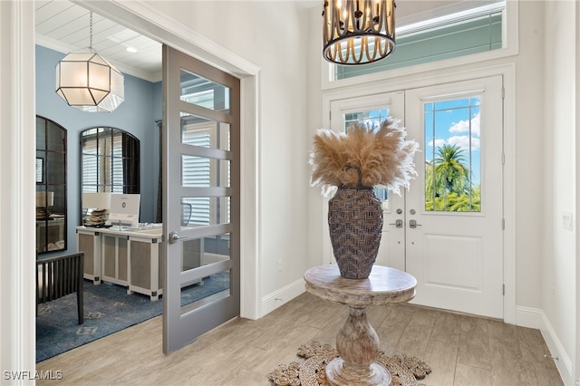 foyer entrance with a healthy amount of sunlight, baseboards, a notable chandelier, and french doors