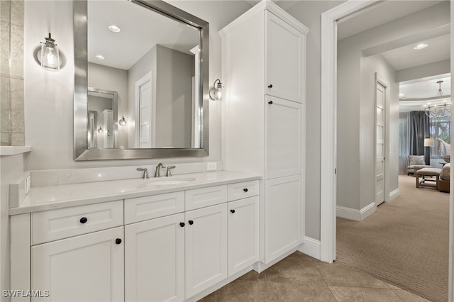 bathroom featuring tile patterned floors, baseboards, recessed lighting, a notable chandelier, and vanity
