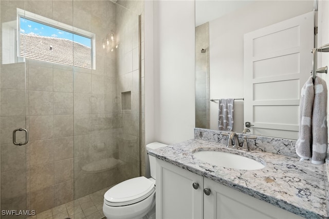 full bath with toilet, vanity, and a stall shower