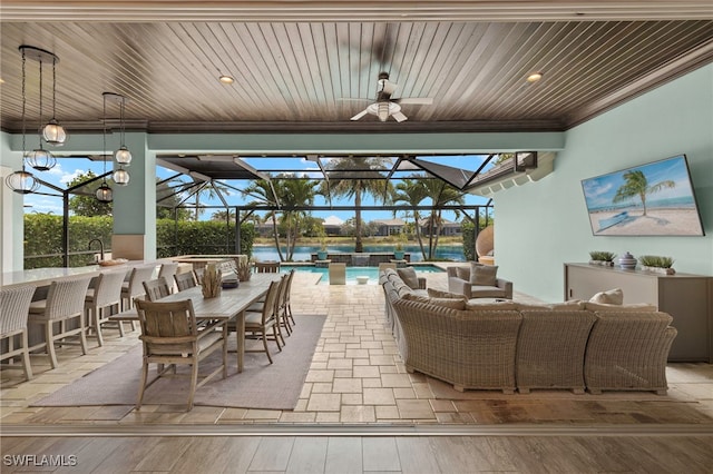 view of patio with an outdoor pool, a ceiling fan, outdoor dry bar, and glass enclosure