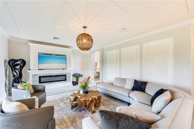 19128 Elston Way, Estero, FL 33928 - living area featuring arched walkways, wood finished floors, ornamental molding, a glass covered fireplace, and a decorative wall