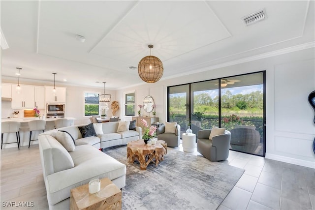 19128 Elston Way, Estero, FL 33928 - living room with a raised ceiling, ornamental molding, a chandelier, and light tile patterned flooring