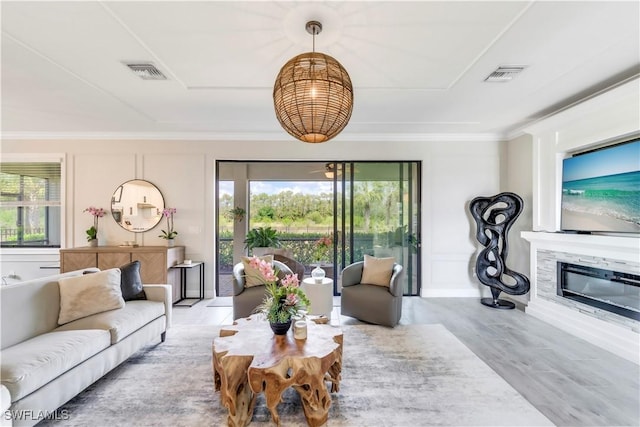 19128 Elston Way, Estero, FL 33928 - living area featuring plenty of natural light, ornamental molding, a glass covered fireplace, and wood finished floors