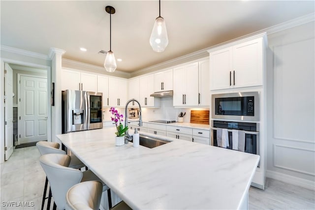 19128 Elston Way, Estero, FL 33928 - kitchen featuring stainless steel appliances, a sink, crown molding, white cabinetry, and a kitchen island with sink