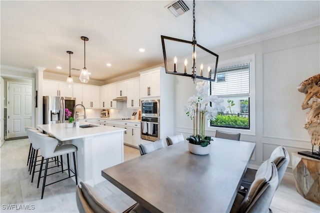 19128 Elston Way, Estero, FL 33928 - dining space with a chandelier, ornamental molding, recessed lighting, and a decorative wall