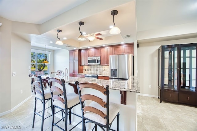 11029 Mill Creek Way Unit 406, Fort Myers, FL 33913 - kitchen featuring stainless steel appliances, backsplash, a raised ceiling, and light tile patterned floors