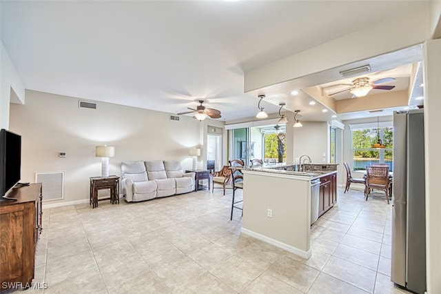11029 Mill Creek Way Unit 406, Fort Myers, FL 33913 - kitchen featuring ceiling fan, appliances with stainless steel finishes, a breakfast bar area, and light tile patterned floors