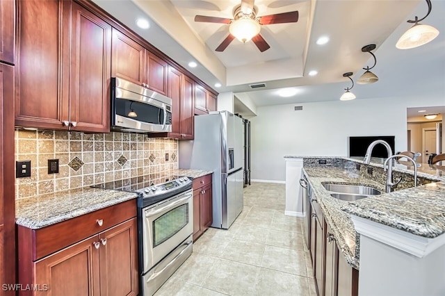 11029 Mill Creek Way Unit 406, Fort Myers, FL 33913 - kitchen with appliances with stainless steel finishes, dark brown cabinets, tasteful backsplash, ceiling fan, and a tray ceiling