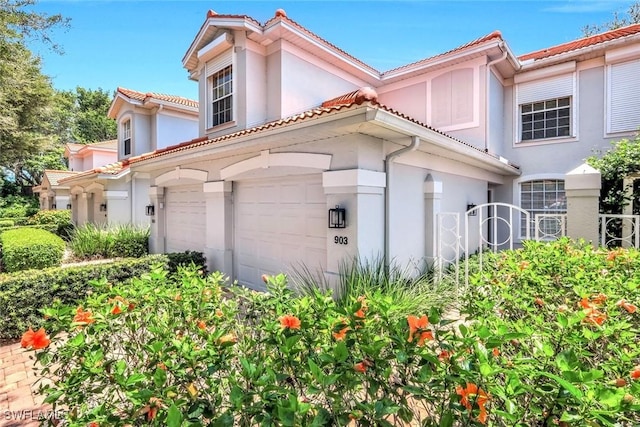 2190 Arielle Dr Unit 903, Naples, FL 34109 - mediterranean / spanish-style home with stucco siding, a tile roof, and an attached garage