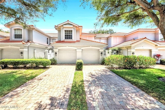 2190 Arielle Dr Unit 903, Naples, FL 34109 - mediterranean / spanish-style house with a tile roof, a front lawn, a garage, stucco siding, and decorative driveway