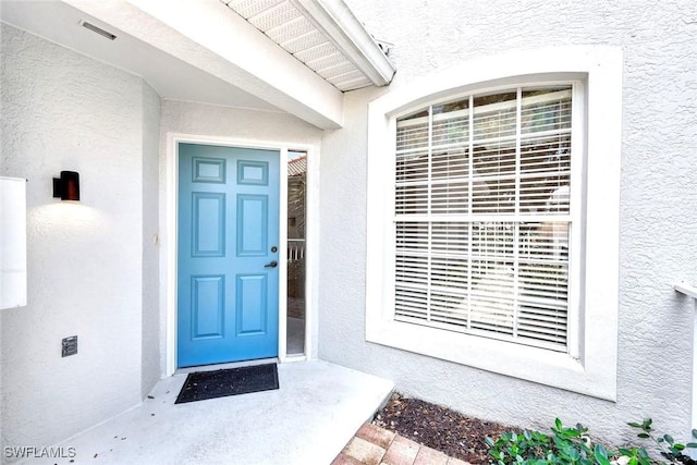 2190 Arielle Dr Unit 903, Naples, FL 34109 - view of exterior entry with visible vents and stucco siding