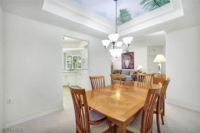 2190 Arielle Dr Unit 903, Naples, FL 34109 - dining room with baseboards, a tray ceiling, a notable chandelier, and light colored carpet