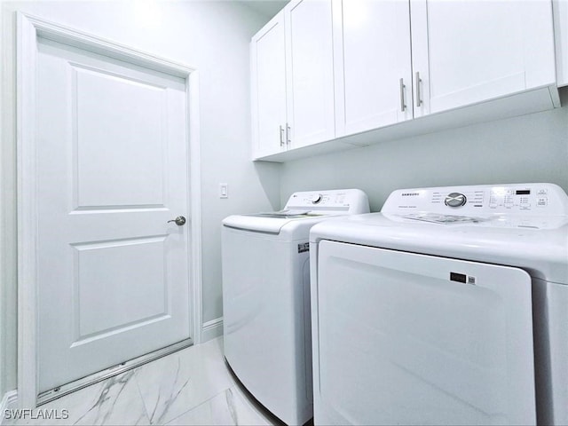 3400 23rd St W, Lehigh Acres, FL 33971 - laundry area with cabinet space, washing machine and dryer, and marble finish floor