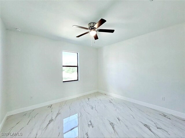 3400 23rd St W, Lehigh Acres, FL 33971 - unfurnished room with baseboards, marble finish floor, and ceiling fan