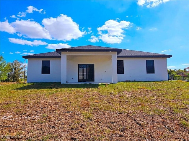 3400 23rd St W, Lehigh Acres, FL 33971 - back of house with stucco siding and a lawn