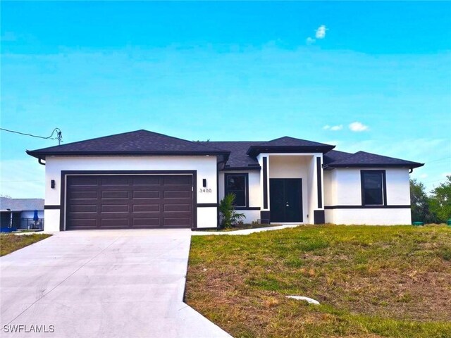 3400 23rd St W, Lehigh Acres, FL 33971 - prairie-style home with stucco siding, an attached garage, driveway, and a front yard