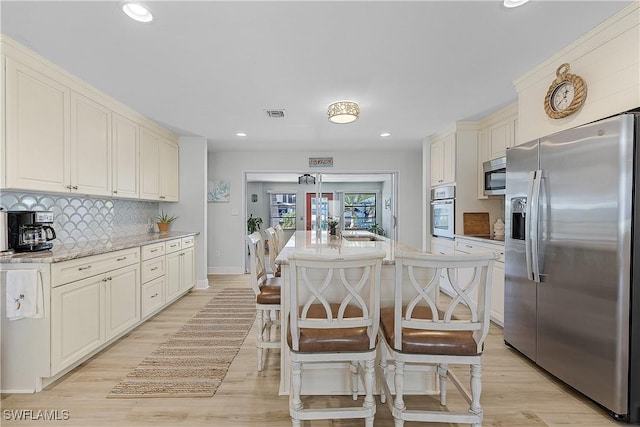 3797 Emerald Ave, Saint James City, FL 33956 - kitchen with backsplash, stainless steel appliances, light wood-type flooring, and a sink