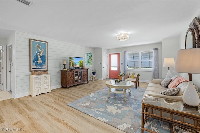 3797 Emerald Ave, Saint James City, FL 33956 - living room featuring baseboards, light wood-style flooring, visible vents, and wooden walls