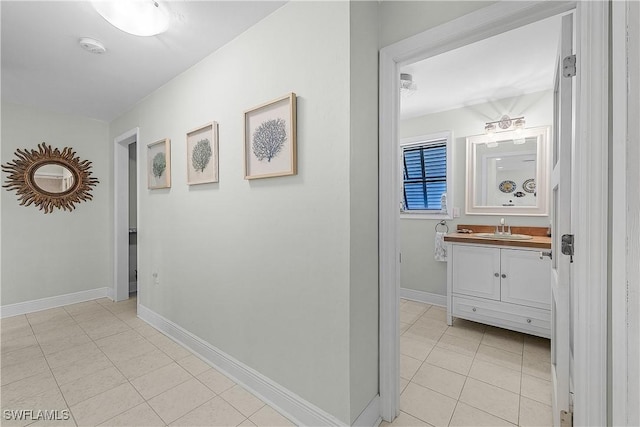 3797 Emerald Ave, Saint James City, FL 33956 - hallway with baseboards, a sink, and light tile patterned floors