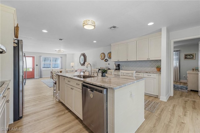 3797 Emerald Ave, Saint James City, FL 33956 - kitchen featuring a kitchen island with sink, light wood-style flooring, a sink, visible vents, and appliances with stainless steel finishes
