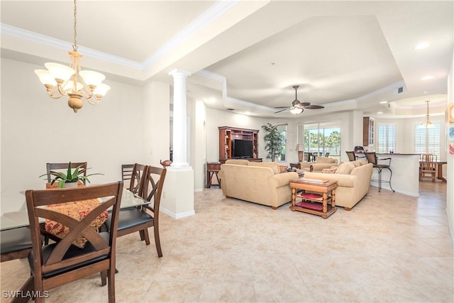 living room with light tile patterned flooring, crown molding, a tray ceiling, and decorative columns