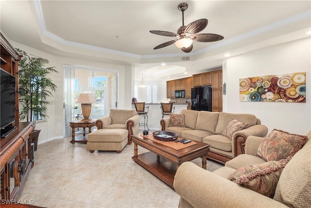 living room featuring light tile patterned floors, a raised ceiling, crown molding, and a ceiling fan