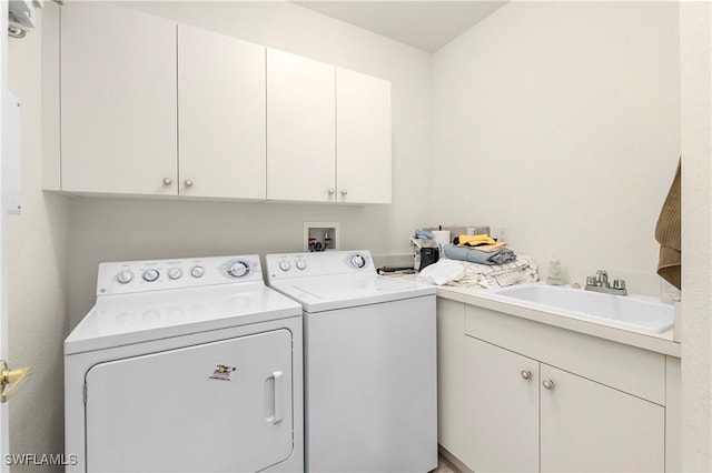 clothes washing area with a sink, cabinet space, and washing machine and dryer