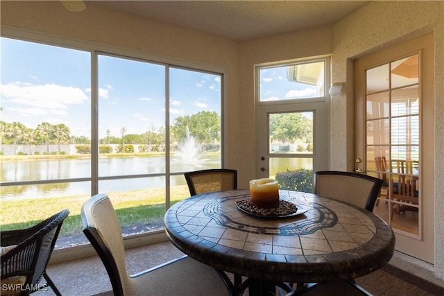 sunroom featuring a wealth of natural light and a water view