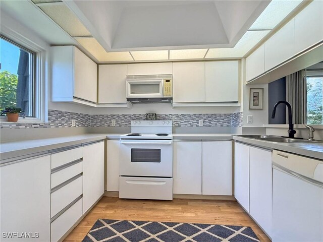 1632 Spoonbill Ln Unit B, Naples, FL 34105 - kitchen featuring white appliances, a sink, white cabinets, light countertops, and decorative backsplash