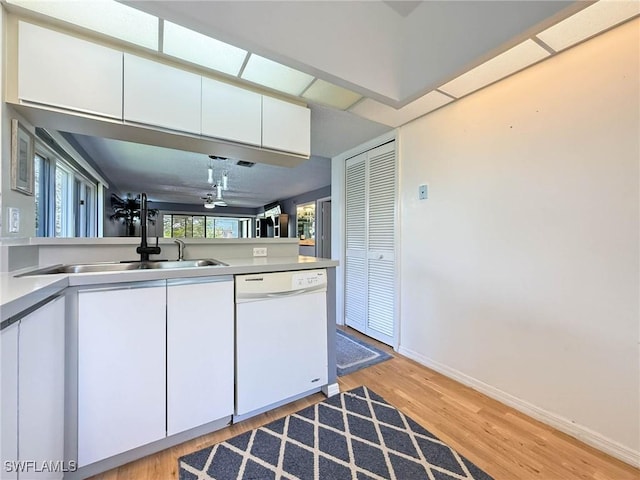 1632 Spoonbill Ln Unit B, Naples, FL 34105 - kitchen with dishwasher, a sink, light wood finished floors, white cabinets, and baseboards